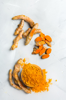 t. Organic orange turmeric root and powder, curcuma longa on a cooking table. Indian oriental low cholesterol spices. Top view flat lay background