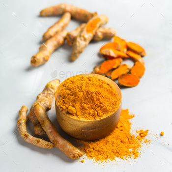 t. Organic orange turmeric root and powder, curcuma longa on a cooking table. Indian oriental low cholesterol spices