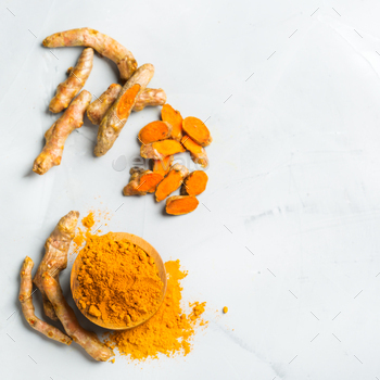 t. Organic orange turmeric root and powder, curcuma longa on a cooking table. Indian oriental low cholesterol spices. Copy space background, top view