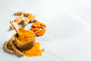 t. Organic orange turmeric root and powder, curcuma longa on a cooking table. Indian oriental low cholesterol spices. Copy space background