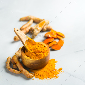 t. Organic orange turmeric root and powder, curcuma longa on a cooking table. Indian oriental low cholesterol spices