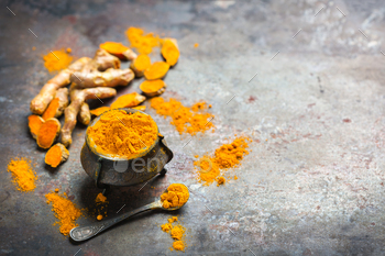 t. Organic orange turmeric root and powder, curcuma longa on a grunge cooking table. Indian oriental low cholesterol spices. Copy space background