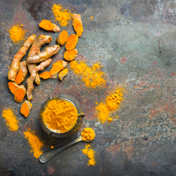 t. Organic orange turmeric root and powder, curcuma longa on a grunge cooking table. Indian oriental low cholesterol spices. Top view flat lay