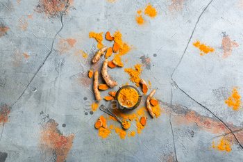 t. Raw organic orange turmeric root and powder, curcuma longa on a grunge cooking table. Indian oriental low cholesterol spices. Copy space background