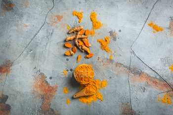 t. Raw organic orange turmeric root and powder, curcuma longa on a grunge cooking table. Indian oriental low cholesterol spices. Top view flat lay