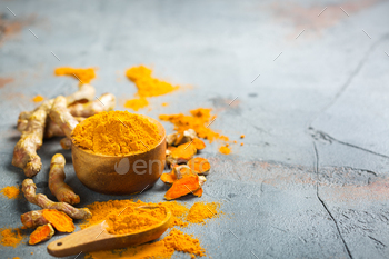 t. Raw organic orange turmeric root and powder, curcuma longa on a grunge cooking table. Indian oriental low cholesterol spices. Copy space background