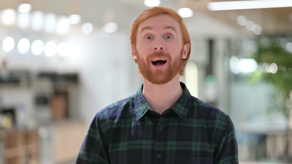 Portrait of Cheerful Beard Redhead Man Talking on Video Call