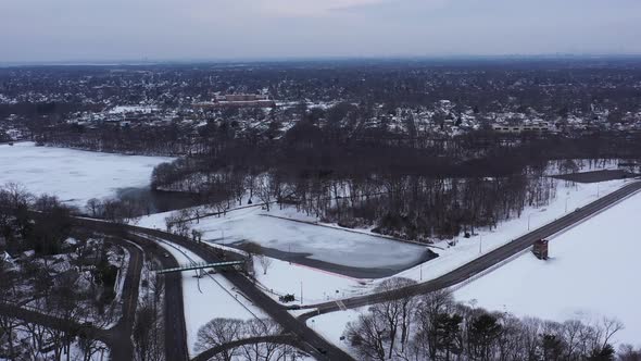 An aerial view from a drone, over a frozen lake during sunrise on a cloudy morning. The camera dolly