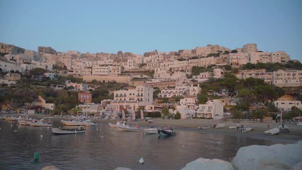 Peschici harbour sunset vibes. Buildings uphill with boats floating in the Adriatic sea.