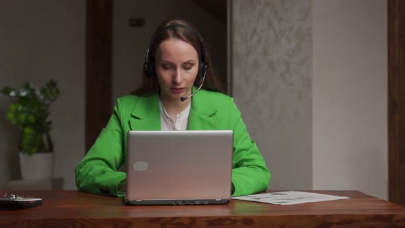 Consultant in Headset Communicates with Client Using Laptop