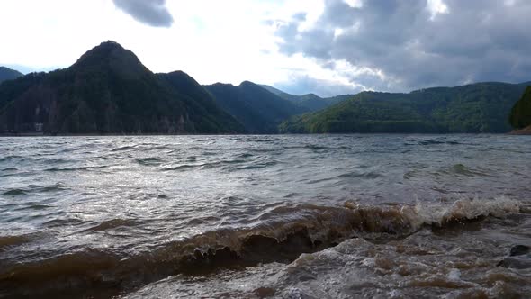 Mountain lake with big waves caused by wind. Beautiful mountain lake. Sailing on a mountain lake.