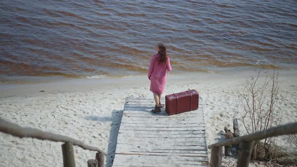 High Angle View of Confident Slim Caucasian Woman Looking Away Standing on Pier Sitting Down on