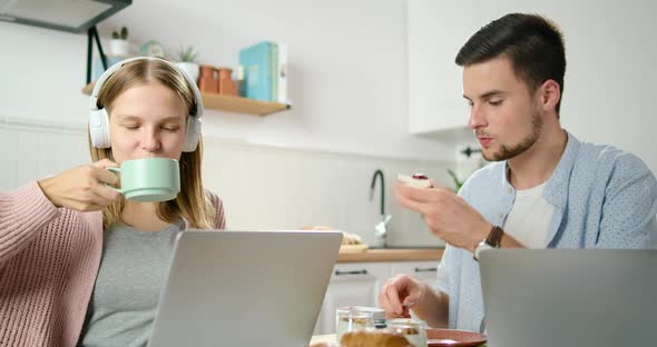 Lady Talks Online By Video Call. Couple Work on Laptop in Kitchen in Home Office