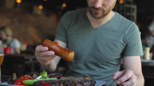 Man Salting Steak Meat At Barbecue Restaurant Closeup