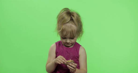 Girl in Purple Dress with Chocolate Egg. Happy Four Years Old Child. Chroma Key