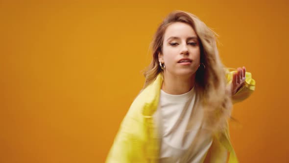 Woman Professional Dancer Dancing in Studio Against Yellow Background