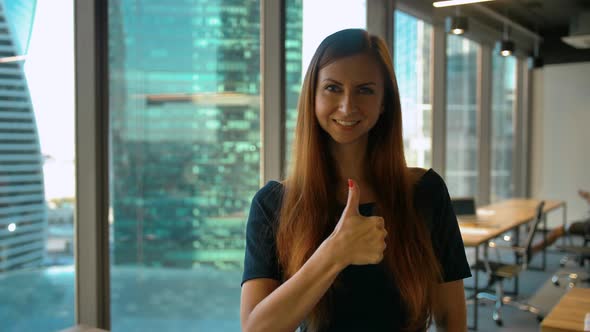 Get Like. Optimistic Businesswoman Makes Hand Gestures Thumb Up Sign in Office