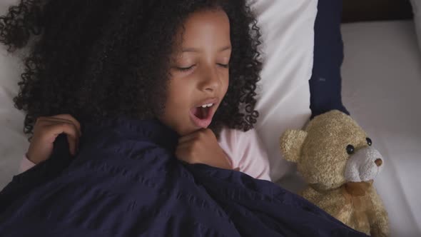 African american girl sleeping and yawning in her bed