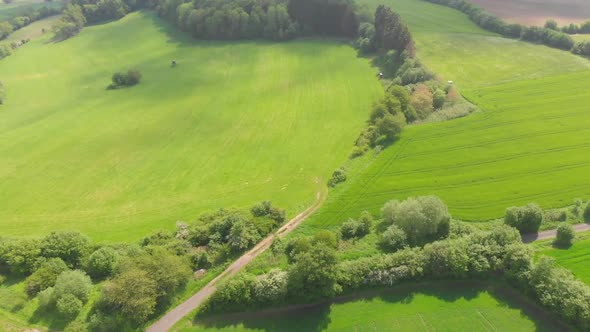 flying over rolling hills with fields in a rural countryside
