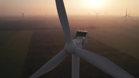 Close-up of wind turbine blades at sunset or sunrise.