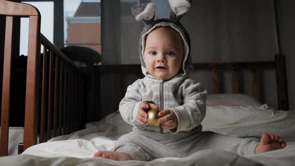 Cute Toddler Boy in Bunny Ears with Easter Gift