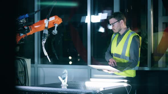 Maintenance Man is Studying a Robotic Mechanism