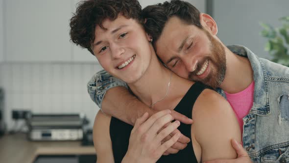 Portrait of Two Happy Guys Feeling in Love with Each Other Standing Hugging in Their New Apartment