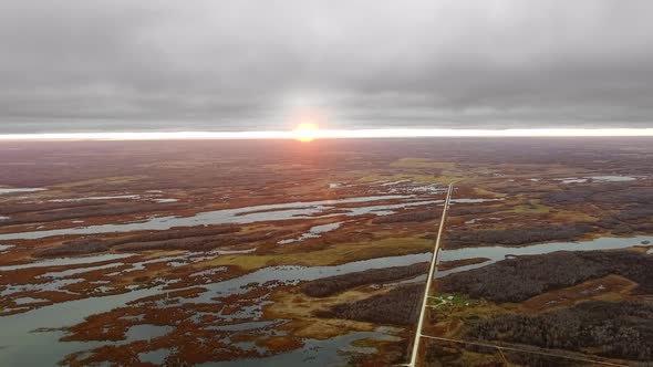 Field with lakes, a road and a small settlement at sunset in North Shoal Lake, Manitoba, Canada