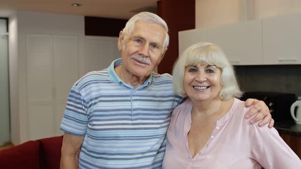 Senior Couple Retired Grandparents Husband and Wife Happy Faces Embracing at Home, Hugging, Laughing