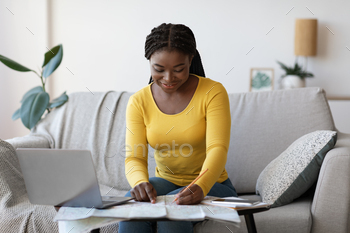 Planning Trip. Happy black woman choosing travel destination on map at home