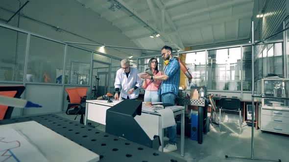 Team of Engineers in a Laboratory with Functioning Robots