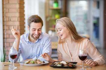Handsome young man and his beloved woman having festive dinner with wine and yummy food at / Photodune, Misc
