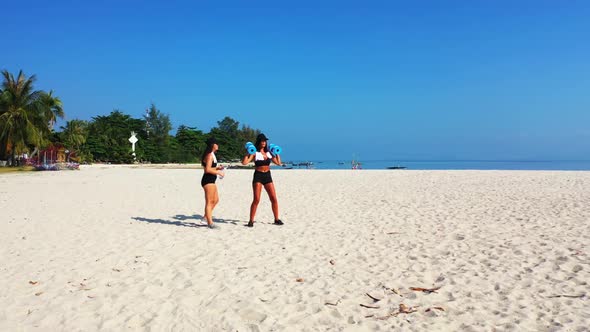 Girls tan on beautiful shore beach time by blue green ocean and white sand background of Koh Phangan