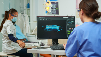 dental fingerprint of patient, while specialist doctor with face mask speaks to man with toothache sitting on stomatological chair preparing tools