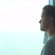 Young Man Stands Near a Big Window Listens to Music in Headphones - VideoHive Item for Sale