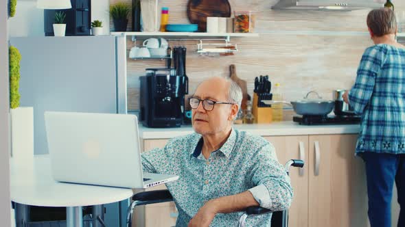 Elderly Disabled Person Working on Laptop