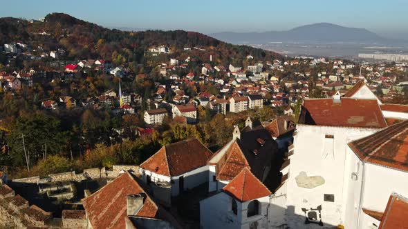 Aerial drone view of The Citadel in Brasov at sunrise, Romania. Medieval fortress on the top of a hi