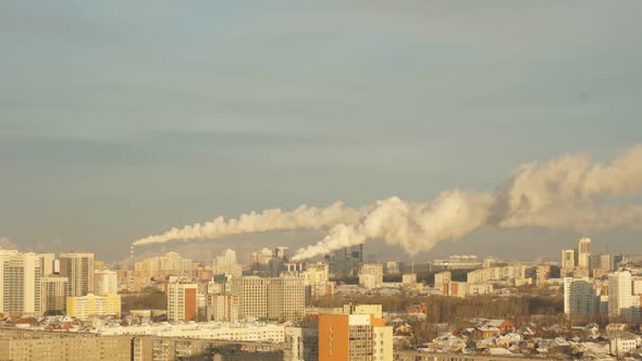 City Pipes Emit Steam Into the Atmosphere Against the City Skyline