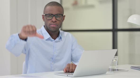 Thumbs Down By African Man with Laptop