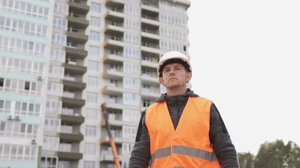 Civil engineer is on a construction site wearing a white helmet.