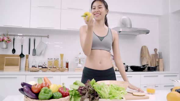 Young Asian woman feeling happy dancing, listen to music and making salad lots of nutrition.
