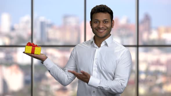 Smiling Businessman Presenting Gift Box