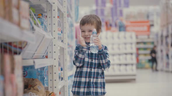 Little Boy In The Supermarket Choose a Bottle Of Mineral Water