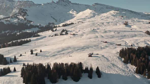 Dolly forward drone shot towards ski chalet and slope in the Italian dolomites