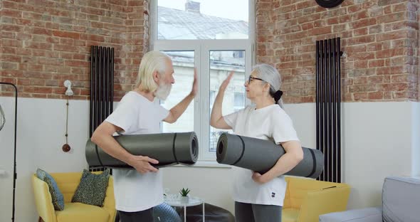 Senior Couple in Sportswear Giving High Five Each other Before Start to do exercises