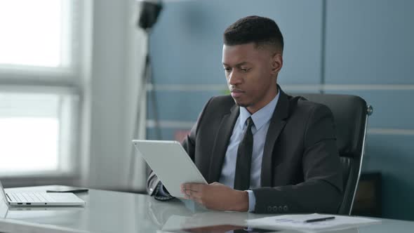 African Businessman using Tablet while Sitting in Office