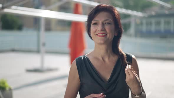 Gorgeous Confident Woman Looking Away Standing in Sunshine on City Street Outdoors