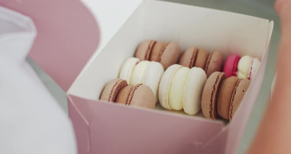 Macarons In A Gift Box In Hands Of Female Confectioner