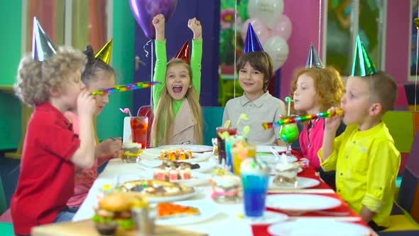 Kids in Colorful Hats Are Celebrating Birthday at Entertainment Center.