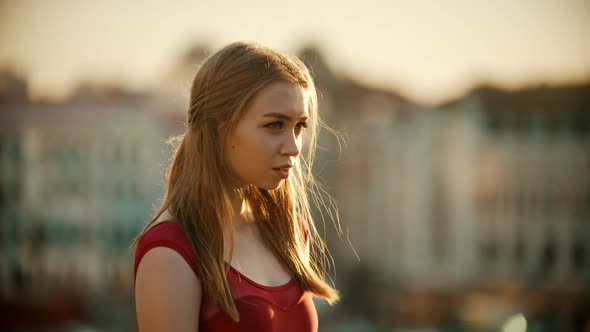 A Young Inspired Woman in Red Dress Standing on the Roof on Sunset